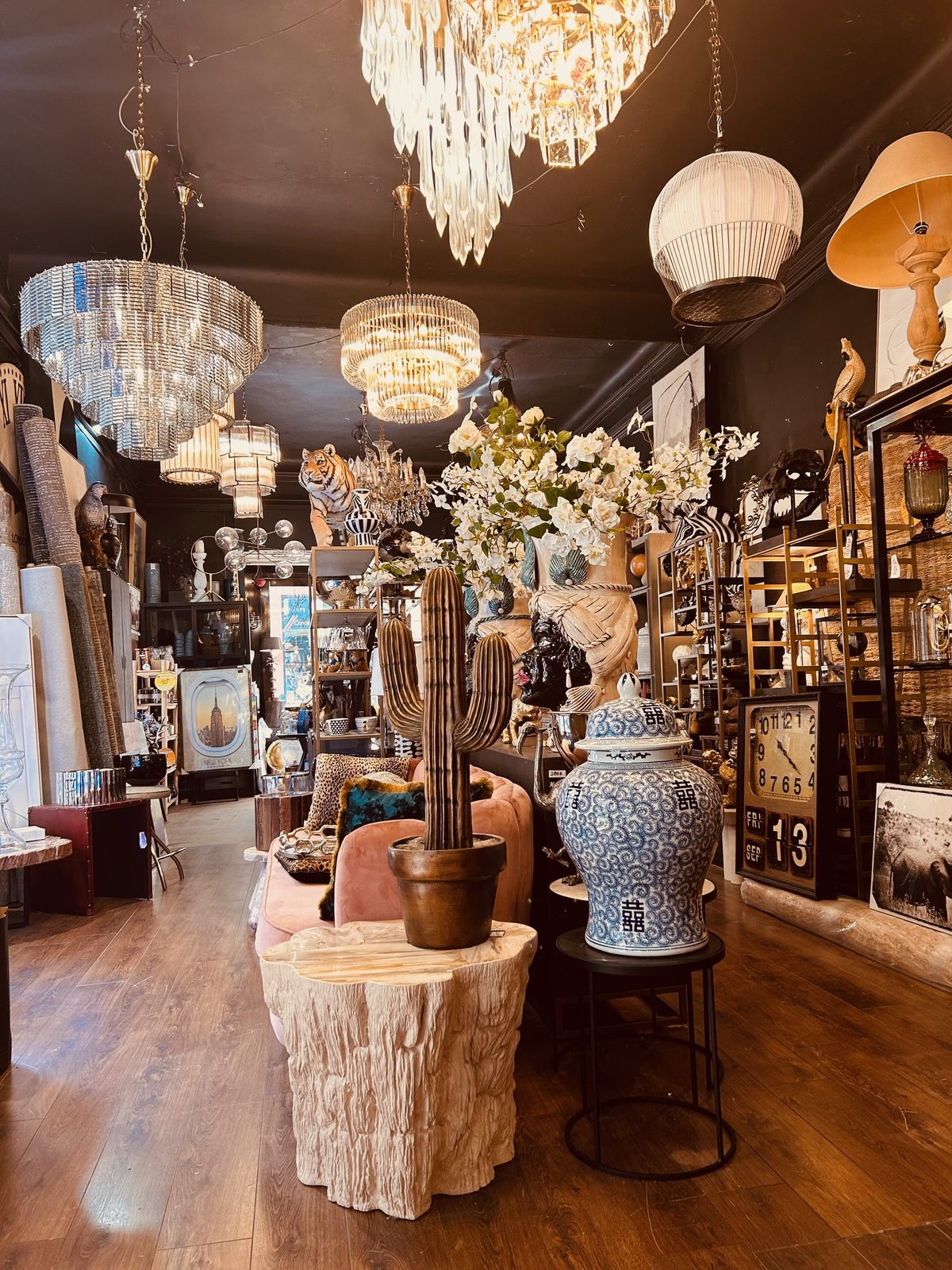 Vue du showroom : lustres, lampes et objets rares dans une ambiance feutrée