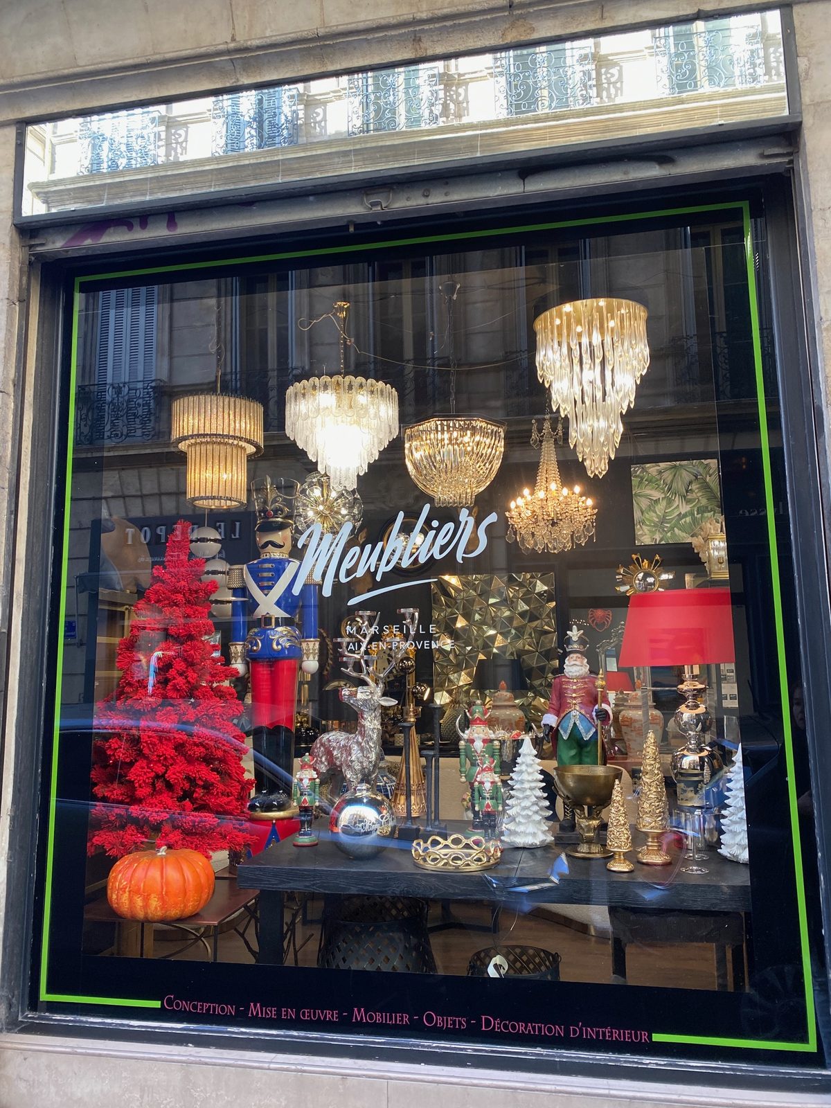 Vitrine de la boutique Meubliers, rue Edmond Rostand à Marseille : lustres en cristal, casse-noisettes et décor de fêtes